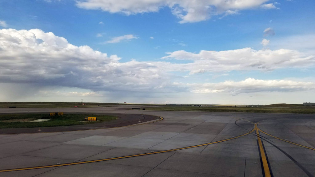 Airport runway with clouds in the distance.