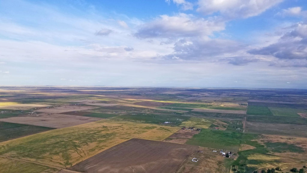 Green and yellow fields as seen from a plane above.